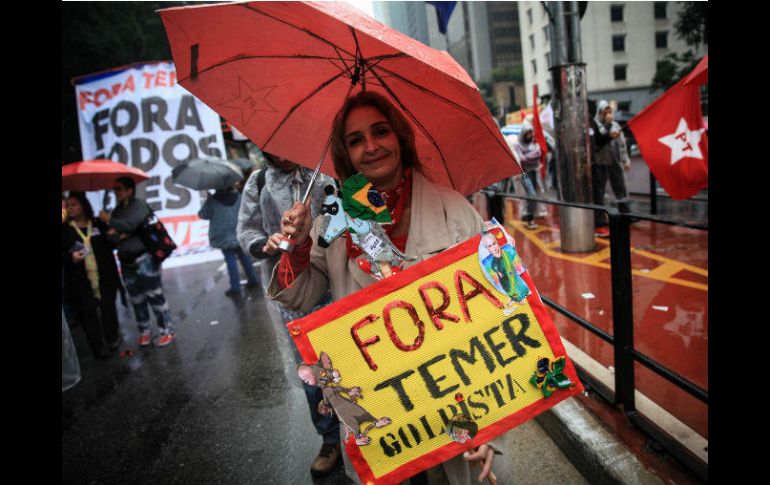 Con paraguas e impermeables, los brasileños salieron a mostrar su descontento con  Michel Temer. EFE / F. Bizerra