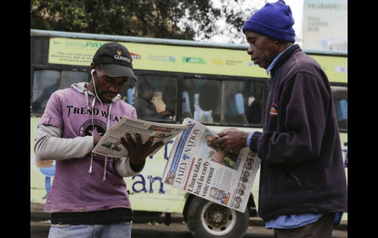 Dos ciudadanos leen las informaciones sobre las elecciones generales en la prensa local en Nairobi. EFE / D. Irungu